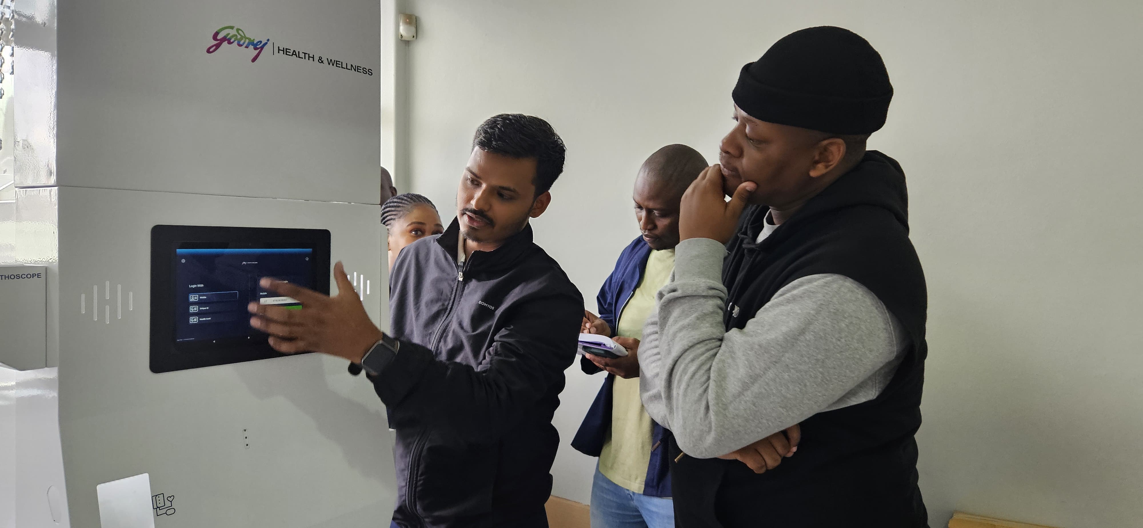 Man demonstrates login screen of a Godrej Health kiosk